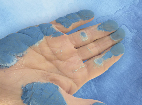 Die Abbildung zeigt eine flach ausgestreckte Hand, die durch Pigmentpulver blau gefärbt ist. Die Fotoaufnahme stammt vom DUERER-Team.