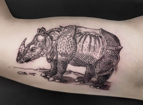 Die Abbildung zeigt einen tätowierten Oberarm eines Mann. Die Vorlage des Tattoos war das von Albrecht Dürer im Jahr 1515 geschaffene Werk "Das Rhinozerus". Die Fotoaufnahme stammt von LeonKa.