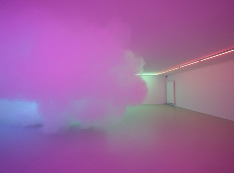 Zora Kreuzer: Cloud Nine, 2022; Aufnahme aus dem Museum gegenstandsfreier Kunst in Otterndorf, © Zora Kreuzer & VG Bild-Kunst Bonn, 2024; Fotoaufnahme von Alistair Overbruck. Die Aufnahme zeigt einen leeren Raum, in dem eine mit einer Nebelmaschine erzeugte Wolke schwebt. Durch an der Decke befestigte Beleuchtung wird die Wolke und Szenerie in blau-violett-rosanes Licht getaucht. Die Aufnahme stammt von Alistair Overbruck.